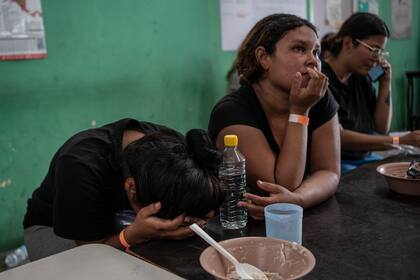 Yeneska García, inmigrante venezolana, llora con la cabeza entre las manos mientras come en el albergue Oasis de Paz del Espíritu Santo Amparito en Villahermosa, México. (AP Foto/Félix Márquez)