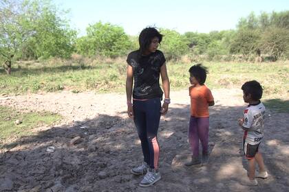 Yisela camina hasta la represa casi seca que está a unos metros de su casa, acompañada por sus primos Néstor (5) y Alejandro (6).