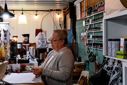 Yvonne Wallech mira su teléfono móvil mientras está conectada a una señal wifi de su propiedad cuando atiende su tienda de regalos en Green Bank, West Virginia