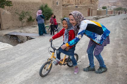 Zakia Mohammadi le enseña a una niña afgana a andar en bicicleta