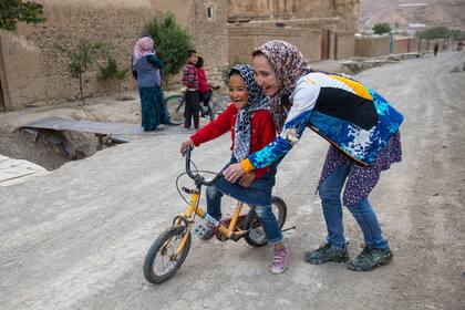Zakia Mohammadi le enseña a una niña afgana a andar en bicicleta