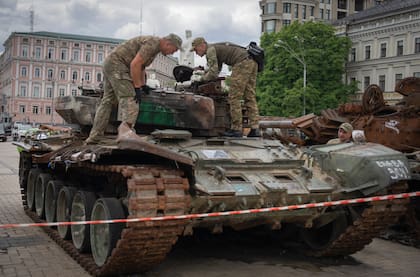 Zapadores inspeccionan un tanque ruso dañado instalado como símbolo de guerra en el centro de Kyiv, Ucrania, el jueves 15 de junio de 2023