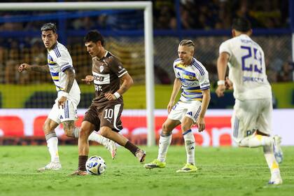 Zapiola domina la pelota ante la mirada de Di Lollo y Ascacibar