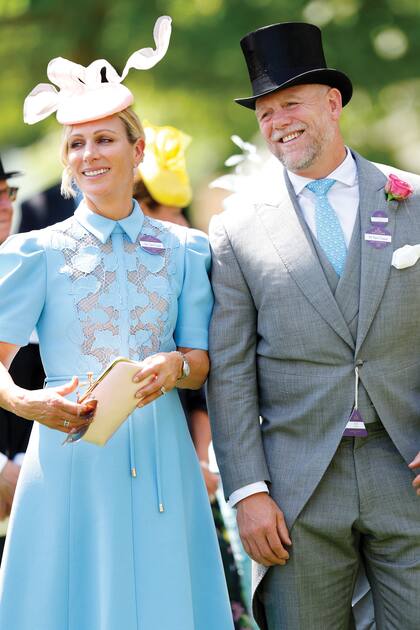 Zara Tindall, sobrina del Rey, junto a su marido Mike. Para el primer día de carreras, la hija de la princesa Ana llevó un vestido celeste con corte en la cintura, cuello camisero y delantera con flores de la diseñadora Rebecca Vallance, y lo destacó con accesorios en rosa empolvado: tocado de Sarah Cant y clutch de Anya Hindmarch.