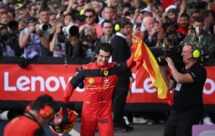 El ganador de la carrera, el piloto español de Ferrari, Carlos Sainz Jr, ondea una bandera española después de ganar el Gran Premio de Gran Bretaña de Fórmula Uno en el circuito de carreras de Silverstone en Silverstone, centro de Inglaterra, el 3 de julio de 2022. (Foto de JUSTIN TALLIS / AFP)