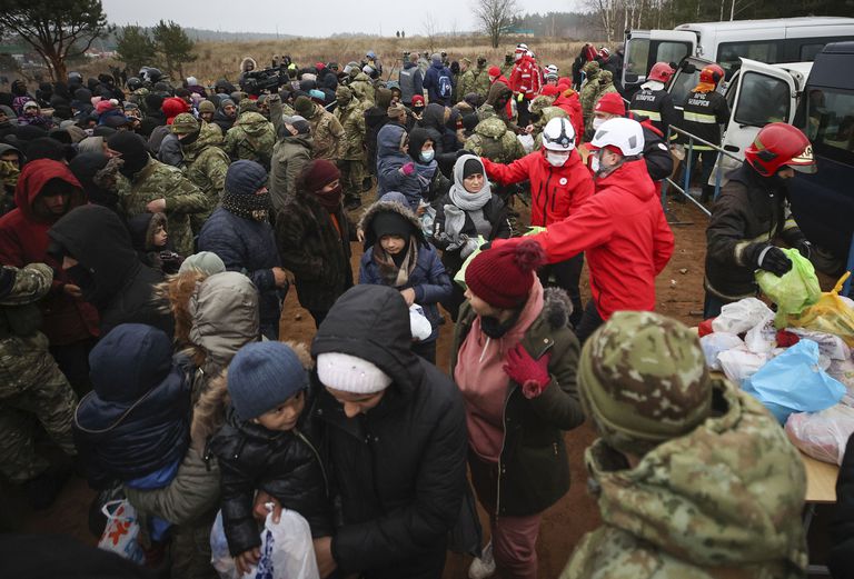 Un hombre huye de un cañón hidrante durante choques entre migrantes y agentes fronterizos polacos en la frontera polaco-bielorrusa cerca de Grodno, Bielorrusia, martes 16 de noviembre de 2021. (Leonid Shcheglov/BelTA via AP)