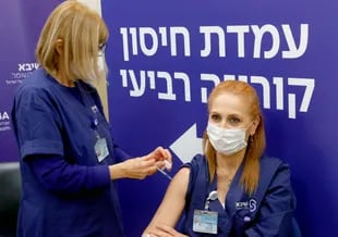 Una enfermera israelí recibió una cuarta dosis de la vacuna contra el coronavirus Pfizer-BioNTech COVID-19 en el Centro Médico Sheba en Ramat Gan, cerca de Tel Aviv, el 27 de diciembre de 2021, mientras el hospital israelí realizaba una prueba del cuarto pinchazo de la vacuna contra los voluntarios del personal. 