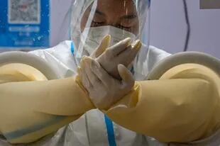 Un trabajador sanitario se prepara para tomar una muestra de hisopo de una persona para analizar el coronavirus en el distrito de Jing'an en Shanghai el 7 de diciembre de 2022.