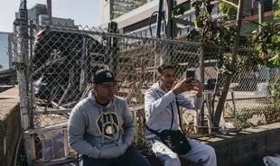 Junior Rojas, izquierda y Terry Antonio Mujica sentados cerca del río Este en Midtown durante un descanso laboral. Hallaron trabajo relativamente pronto tras su llegada a Nueva York, pero cobran la mitad del salario mínimo