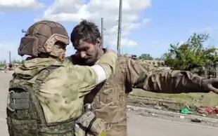Un soldado ruso revisa a un combatiente ucraniano que se rindió en la planta de Azovstal, Mariúpol