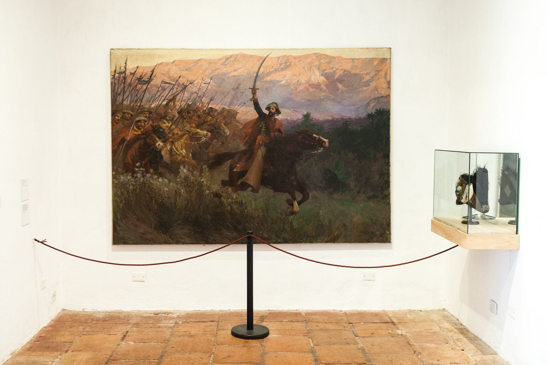 Junto al bicornio, "El Gral. Martín Miguel de Güemes y sus gauchos" es un óleo sobre tela de Antonio Estruch que data de 1912.