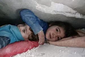 La historia detrás de la emocionante imagen de una niña que protege a su hermano menor entre los escombros en Siria