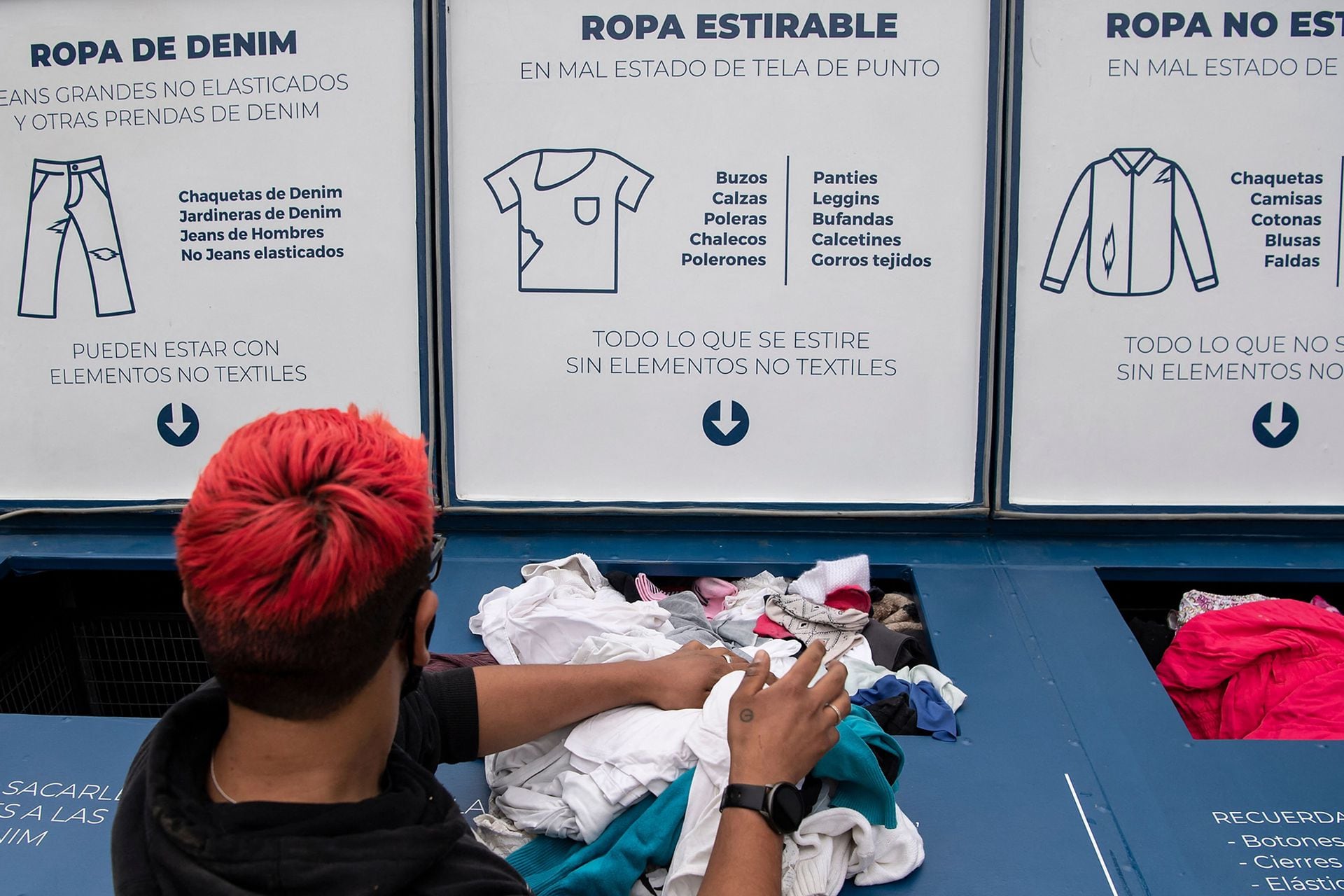 U empleado separa la ropa según su tela para luego ser reciclada