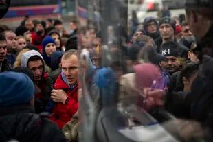 La gente lucha por subir a un autobús mientras intenta salir de Kiev, Ucrania, el jueves 24 de febrero de 2022. 