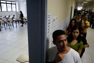 Los votantes que estaban en la fila a la hora del cierre de las elecciones podrán votar igual, con una contraseña (Foto AP/Eraldo Peres)