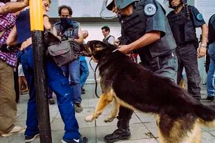 Una reportera gráfica es atacada por un perro de la policía durante los enfrentamientos del 20 de diciembre de 2001, en Plaza de Mayo