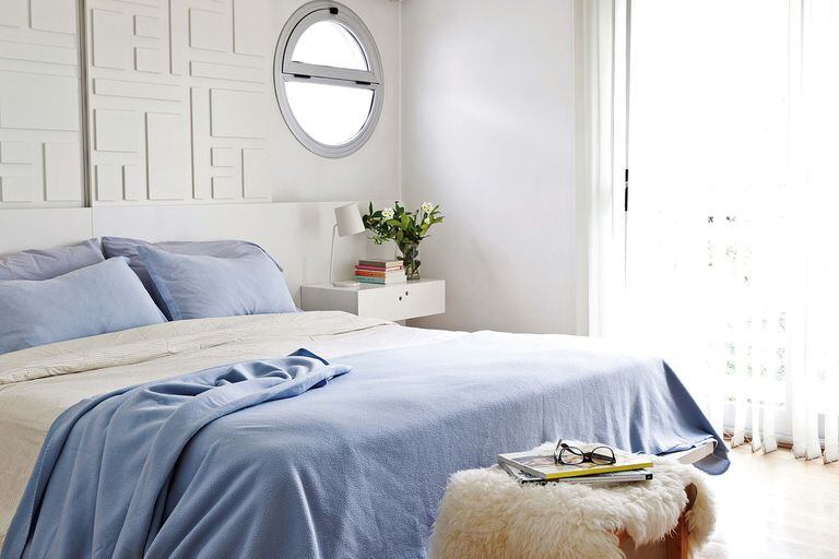 Sobre la cama, un panel corredizo de placas de madera pintadas que se luce casi como un cuadro y sirve de persiana para las claraboyas. Funcionalidad y diseño en un solo movimiento.