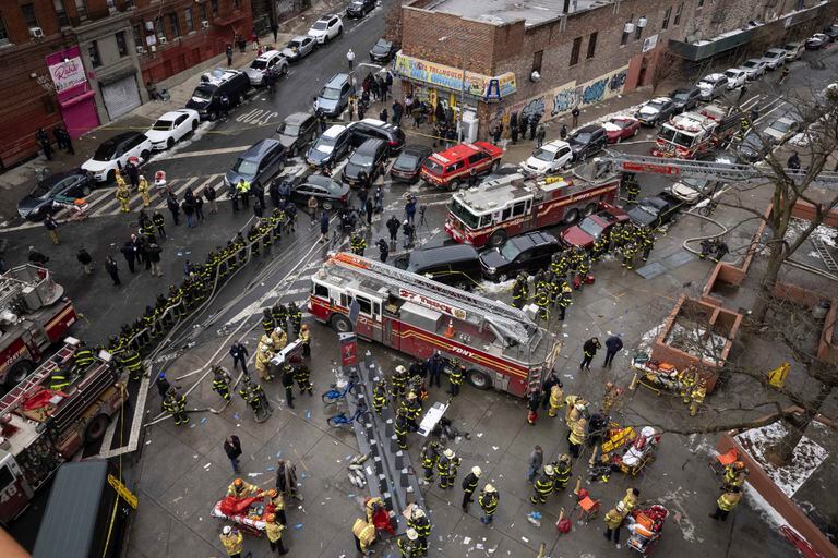 Los bomberos trabajan afuera de un edificio de apartamentos que se incendió el domingo 9 de enero de 2022, en el Bronx, Nueva York. (AP Foto/Yuki Iwamura)
