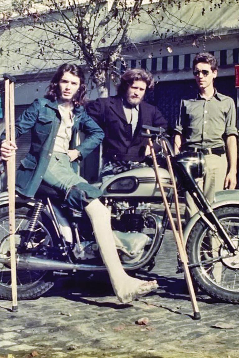Una imagen de su juventud, con yeso y muletas, y su vieja moto y sus amigos, los hermanos Alex y Galo De la Vega. "Tuve que hacer rehabilitación durante un año", cuenta. 
