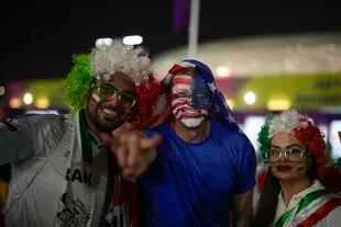 Aficionados iraníes y estadounidenses animan antes del partido del Grupo B que enfrentará a los dos equipos en el estadio Al Thumama, en Doha, Qatar, el 29 de noviembre de 2022. 
