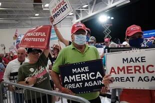 Simpatizantes del presidente Donald Trump sostienen carteles de MAGA (Make America Great Again)
