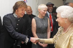 La soberana saluda a Paul Mc Cartney –detrás se ve a Annie Lennox– después del concierto por el 60° aniversario de su ascensión al trono. En 1965, la Reina había distinguido a The Beatles como Miembros de la Orden del Imperio Británico.
