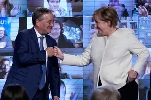La canciller Angela Merkel y el candidato demócrata cristiano Armin Laschet chocan las manos durante un acto de campaña en Baviera