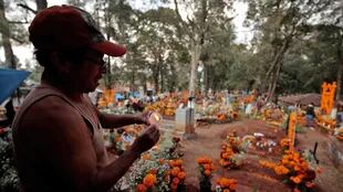 Un hombre prende velas en un cementerio de Tzintzuntzan
