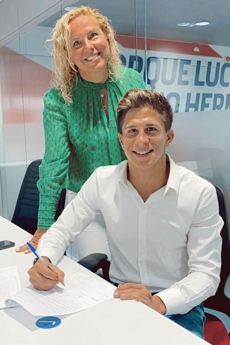 Hace unos pocos días, Giuliano firmó su primer contrato como futbolista profesional con el Atlético y está a disposición de su padre. En la foto, con su tía y representante, al momento de la firma