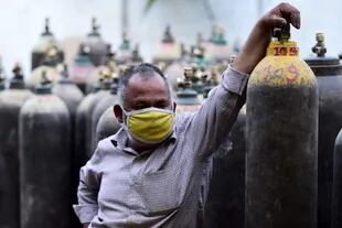 Un hombre aguarda para rellenar un tubo de oxígeno en una estación de carga en Allahabad, India el 20 de abril de 2021

