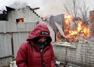 Una mujer en Donetsk, frente a su casa quemada