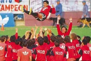 Diego Maradona es lanzado al aire, ante la euforia y los brazos en alto de Solari, en su primer entrenamiento en Newell’s, en 1993.