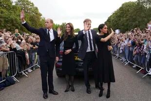 Desde la izquierda, el príncipe británico Guillermo, príncipe de Gales, Kate, princesa de Gales, el príncipe Harry y Meghan, duquesa de Sussex saludan a los miembros del público en el castillo de Windsor, tras la muerte de la reina Isabel II el jueves, en Windsor, Inglaterra, el sábado 10 de septiembre de 2022.