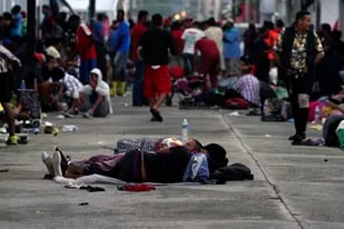 Migrantes, la mayoría procedentes de Centroamérica, duermen en la calle en la localidad de Huixtla, en el estado de Chiapas, México, el martes 26 de octubre de 2021. (AP Foto/Marco Ugarte)