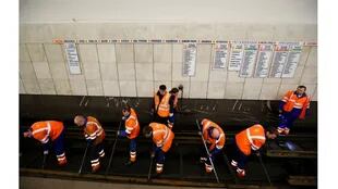 Empleados traban en la reparación de la vía férrea en la estación de metro Sukharevskaya en Moscú, Rusia