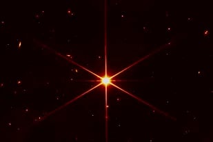 En esta imagen proporcionada por la NASA el miércoles 16 de marzo de 2022 se ve la estrella 2MASS J17554042+6551277, usada para alinear los espejos del Telescopio Espacial James Webb, con galaxias y estrellas rodeándola. (NASA/STScI vía AP)