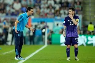 Lionel Scaloni le da indicaciones a Messi durante el partido con Polonia