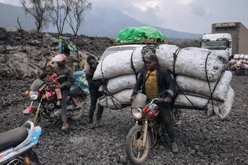 La gente de Goma transporta las mercaderías a través del flujo de lava solidificada del volcán Nyiragongo