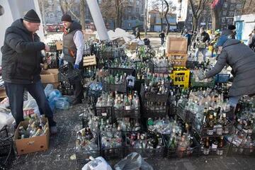 Civiles voluntarios preparan botellas vacías donadas para ser usadas como cócteles Molotov en un centro de recolección ubicado en un estacionamiento de Dnipro, Ucrania, el 27 de febrero de 2022.