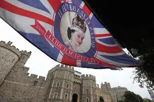 The Union Flag showing an image of Britain's Queen Elizabeth II flies in the breeze next to Windsor Castle in west London (Photo by Adrian Dennis/AFP)