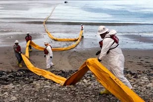 ARCHIVO - Trabajadores preparan una bolla de contención en Refugio State Beach, al norte de Goleta, California, el 21 de mayo de 2015, dos días después de un derrame de crudo en un oleoducto, incidente que contaminó playas y mató y ensució a cientos de aves y mamíferos marinos en la zona. (AP Foto/Jae C. Hong, Archivo)