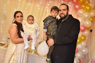 El sacerdote siriano ortodoxo Jorge Bahnam, junto a su esposa Suha y sus dos pequeños hijos durante la fiesta de bautismo de la pequeña