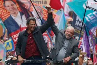 El expresidente de Brasil (2003-2010) y candidato presidencial por el izquierdista Partido de los Trabajadores (PT), Luiz Inácio Lula da Silva (derecha), y el candidato a gobernador de San Pablo, Fernando Haddad (izquierda), saludan a sus seguidores durante un mitin de campaña en San Pablo