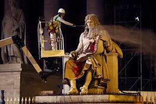Fotografía de archivo del 23 de junio de 2020 de un trabajador municipal de París limpiando la estatua de Jean-Baptiste Colbert, en París. (AP Foto/Thibault Camus, Archivo)