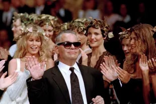 Archivo.- El diseñador alemán Karl Lagerfeld recibe el aplauso de sus modelos al final de su desfile para Chanel de la temporada otoño-invierno 1993-94 en París, el 20 de julio de 1993 (Foto AP/Lionel Cironneau, archivo)