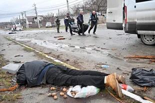 Un hombre muerto yace sobre una calle en Bucha