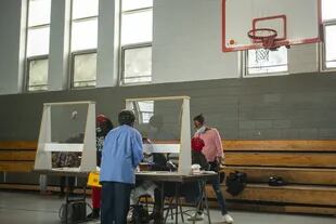 Los trabajadores electorales se sientan detrás de las barreras de plexiglás durante las elecciones primarias del 2 de junio de 2020 en Filadelfia, Pensilvania
