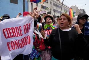 Los partidarios del presidente peruano Pedro Castillo se reúnen con una bandera que dice en español "Cierre del Congreso" en el día de una votación de destitución prevista en el presidente, cerca del Congreso en Lima, Perú, miércoles, 7 de diciembre de 2022.