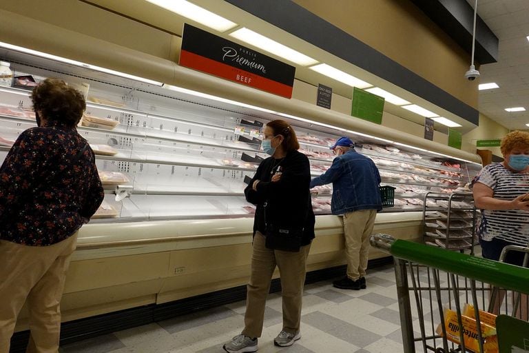 Shelves displaying meat are partially empty as shoppers browse a supermarket on January 11, 2022 in Miami, Florida.