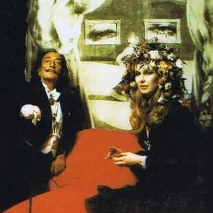 Salvador Dalí, aquí con un fondo de su Retrato de Mae West, estuvo presente en la fiesta y fue también autor de algunos de los ornamentos que llevaron los invitados en sus cabezas